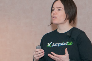 A woman holding a clicker and speaking to the audience.